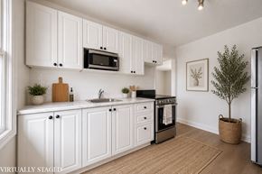 Kitchener apartment for rent - A kitchen with white cabinets and a black stove top oven.