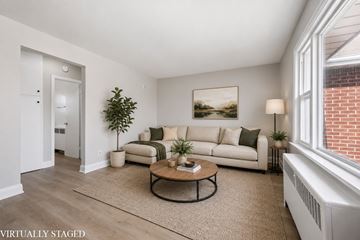 Kitchener apartment for rent - A living room with a couch, coffee table, and a painting on the wall.