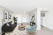 Hamilton apartment for rent - A living room with a black couch, a coffee table, and a blue chair.