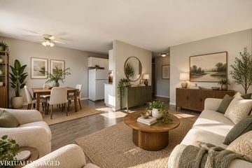 Hamilton apartment for rent - A living room with a white couch, a coffee table, and a dining table with chairs.