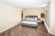Hamilton apartment for rent - A bedroom with a bed, nightstand, and a plant.