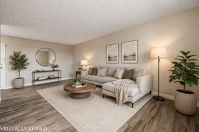 Stoney Creek apartment for rent - A living room with a white couch, a coffee table, and a potted plant.