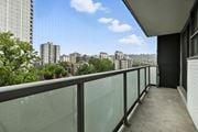 Hamilton apartment for rent - A balcony with a glass railing overlooks a cityscape.