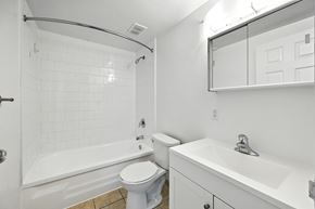Hamilton apartment for rent - A white bathroom with a toilet, sink, and bathtub.