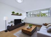 Hamilton apartment for rent - A modern living room with a flat screen TV, a wooden coffee table, and a grey sofa.