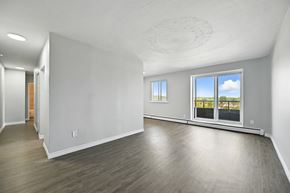 Hamilton apartment for rent - A spacious room with a view of the sky through the windows.