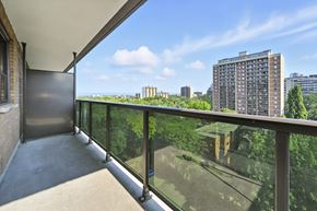 Hamilton apartment for rent - A balcony with a glass railing overlooking a cityscape.