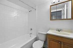 Hamilton apartment for rent - A white bathroom with a toilet, sink, and bathtub.
