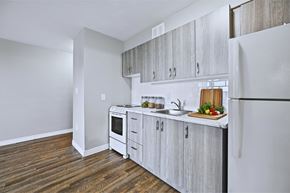 Hamilton apartment for rent - A kitchen with white appliances and wooden cabinets.
