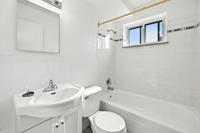 Hamilton apartment for rent - A white bathroom with a toilet, sink, and bathtub.