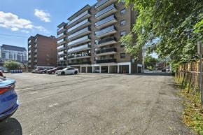 Hamilton apartment for rent - A parking lot with a large building in the background.