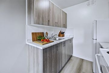 Hamilton apartment for rent - A kitchen with a white refrigerator and wooden cabinets.