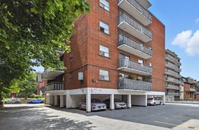 Hamilton apartment for rent - A red brick building with a parking lot in front.