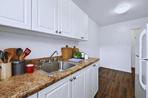 Hamilton apartment for rent - A kitchen with white cabinets and a granite countertop.
