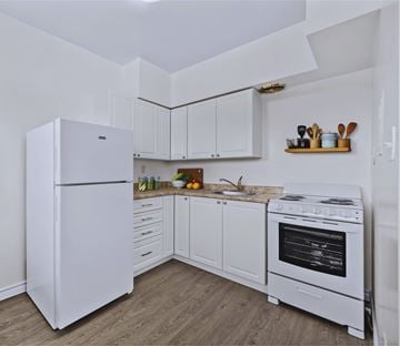 Hamilton apartment for rent - A white kitchen with a refrigerator, oven, and sink.