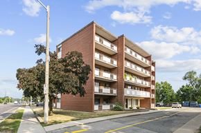 Hamilton apartment for rent - A red brick apartment building with a white street light in front.