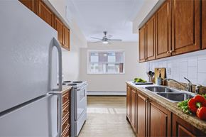 Hamilton apartment for rent - A kitchen with a white refrigerator and wooden cabinets.