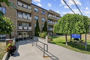 Stoney Creek apartment for rent - A sunny day at a residential building with a blue sign in the front yard.