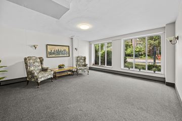 Hamilton apartment for rent - A living room with a grey carpet and a painting on the wall.