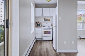 Hamilton apartment for rent - A kitchen with white appliances and wooden floors.