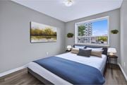 Hamilton apartment for rent - A bedroom with a large bed and a painting on the wall.