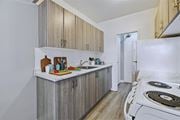 Hamilton apartment for rent - A kitchen with wooden cabinets and a white stove top oven.