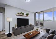 Hamilton apartment for rent - A modern living room with a grey sofa, a wooden coffee table, and a flat-screen TV.