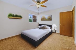 Stoney Creek apartment for rent - A bedroom with a bed, a ceiling fan, and a window with blinds.