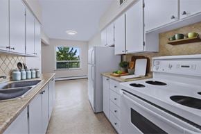 Stoney Creek apartment for rent - A kitchen with white appliances and cabinets.