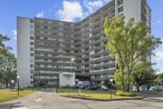 Hamilton apartment for rent - A tall building with a flag on top and a tree in front.