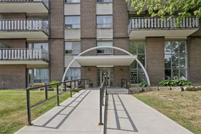 Hamilton apartment for rent - A modern building with a white arched entrance and a metal railing.