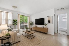 Hamilton apartment for rent - A living room with a couch, a coffee table, a TV, and a plant.