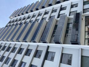 Hamilton apartment for rent - A modern building with a white facade and black balconies.