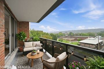 Hamilton apartment for rent - A balcony with a table and chairs overlooking a town.