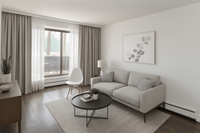 Hamilton apartment for rent - A modern living room with a grey sofa, a white chair, and a coffee table.