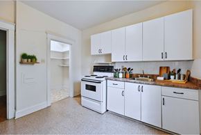 Hamilton apartment for rent - A kitchen with white cabinets and a black stove top oven.