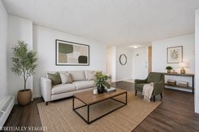Kitchener apartment for rent - A living room with a white couch, a green armchair, and a coffee table.