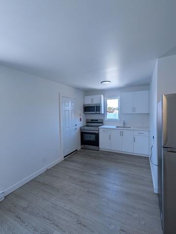 Kitchener apartment for rent - A kitchen with white cabinets and a refrigerator.