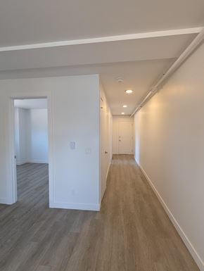 Kitchener apartment for rent - A long hallway with wood floors and white walls.