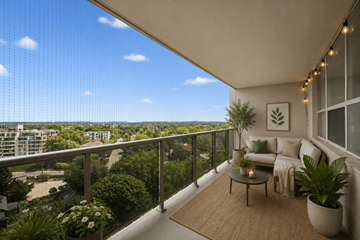 Kitchener apartment for rent - A balcony with a table, couch, and plants overlooking a cityscape.