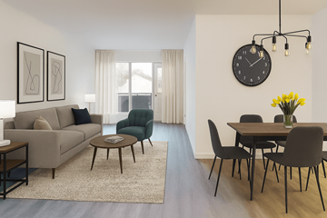Kitchener apartment for rent - A living room with a grey couch, a green armchair, a coffee table, a dining table with chairs, a clock, and a vase of yellow flowers.