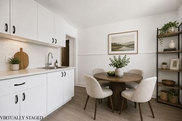 Kitchener apartment for rent - A kitchen with white cabinets and a wooden table with chairs.
