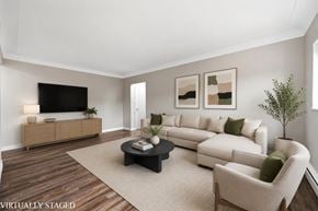 Hamilton apartment for rent - A living room with a white couch, a black coffee table, and a wooden floor.