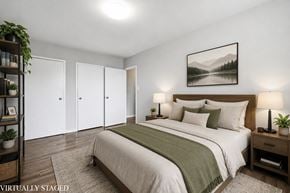 Hamilton apartment for rent - A bedroom with a bed, nightstand, and a painting on the wall.