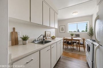 Hamilton apartment for rent - A kitchen with white cabinets and a wooden table.