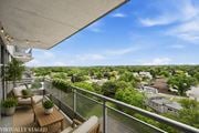 Hamilton apartment for rent - A balcony with a table and chairs overlooking a residential area.