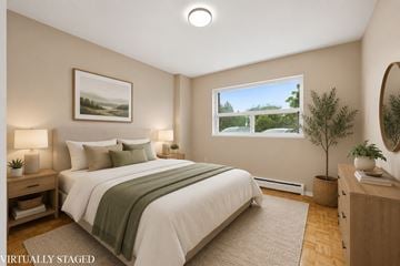 Stoney Creek apartment for rent - A bedroom with a large bed and a painting on the wall.