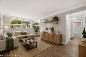 Hamilton apartment for rent - A living room with a couch, a coffee table, and a large window.