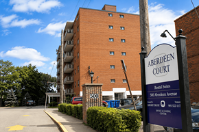 Hamilton apartment for rent - A sign for Aberdeen Court Rental Suites stands in front of a brick building.