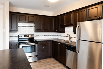 Hamilton apartment for rent - A kitchen with dark brown cabinets and stainless steel appliances.